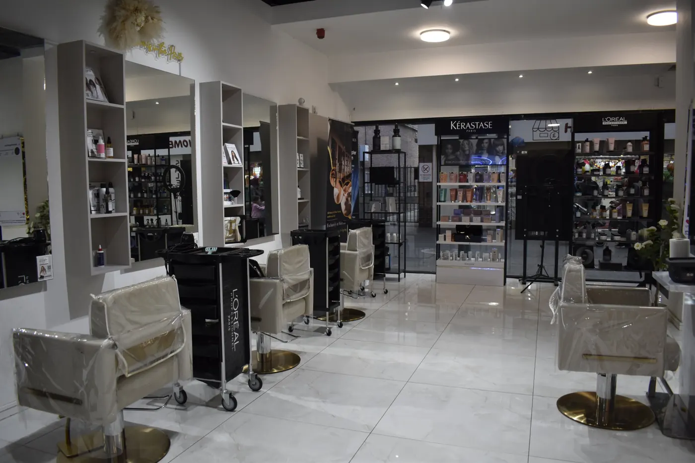 The Glam & Go salon floor, with cream styling chairs and the Kérastase and L'Oréal displays by the window